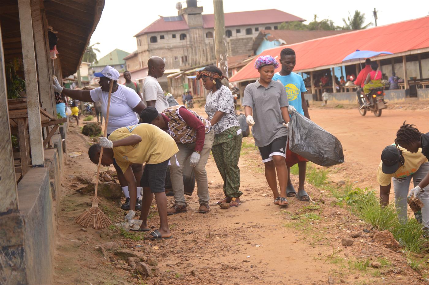 Community members and volunteers cleaning roadside spaces in Soul Clinic.