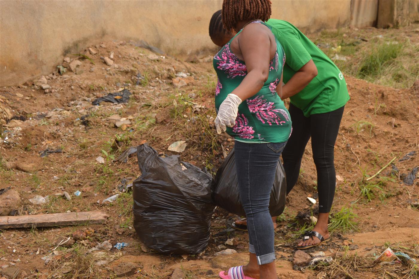 Volunteers carrying collected waste after cleaning affected public spaces.
