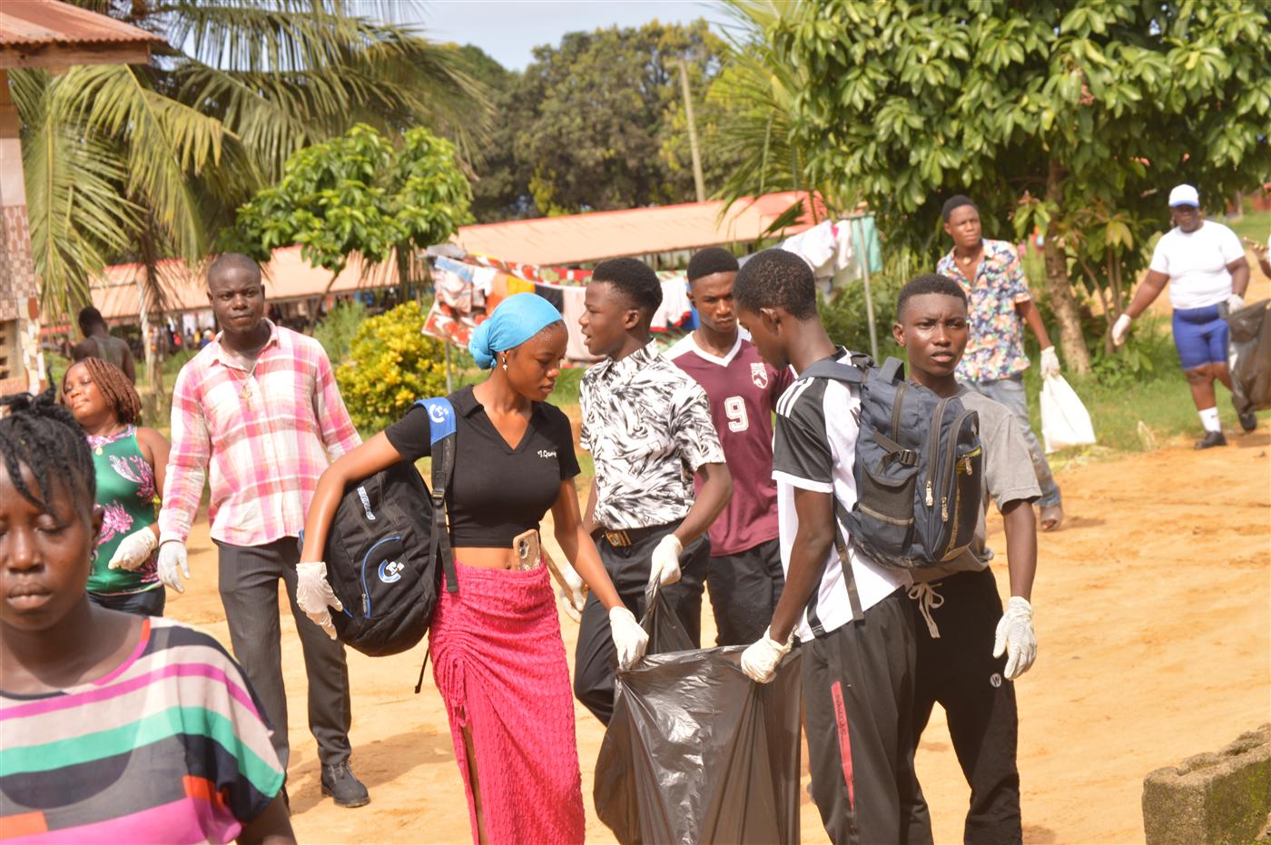 Youth volunteers carrying waste bags during the community clean-up exercise.