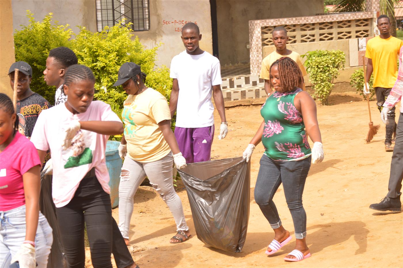 Community members carrying waste bags as part of the World Environment Day observance.