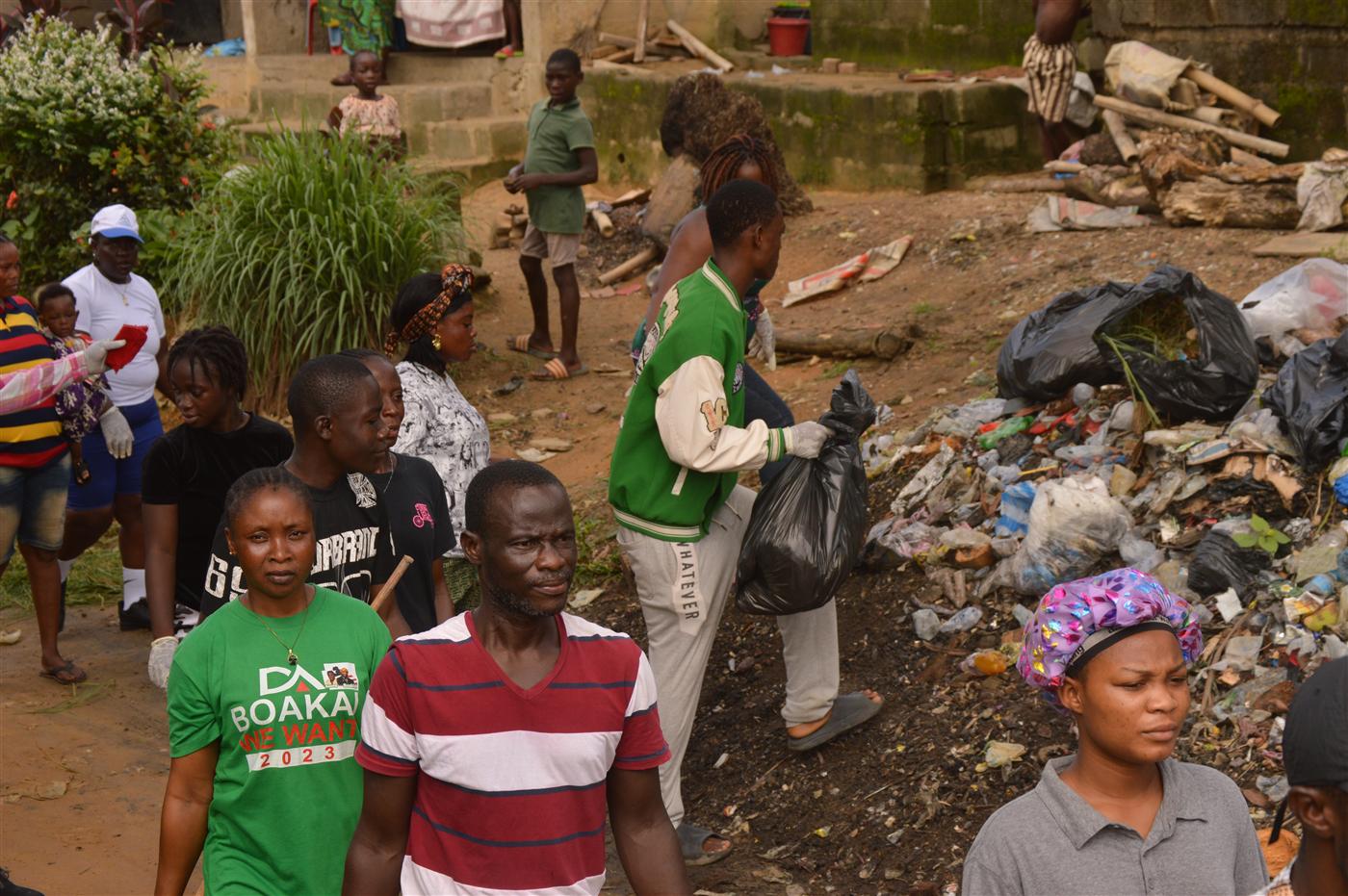 Participants cleaning areas affected by poor waste disposal and blocked drainage.